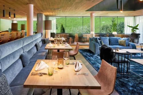 a restaurant with tables and chairs and a couch at ZillergrundRock Luxury Mountain Resort in Mayrhofen