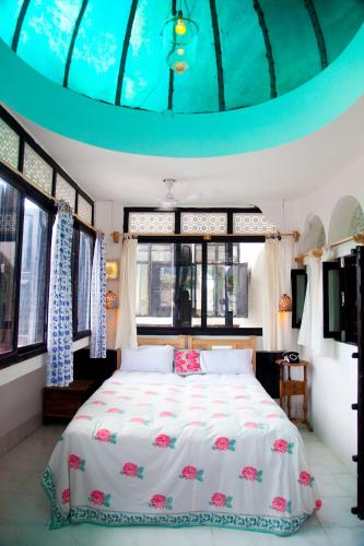 a bedroom with a bed in a room with windows at Inn Seventh Heaven in Pushkar