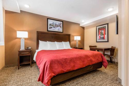 a hotel room with a bed with a red blanket at Rodeway Inn Chicago/Evanston in Lincolnwood