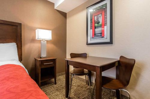 a hotel room with a desk and a bed at Rodeway Inn Chicago/Evanston in Lincolnwood