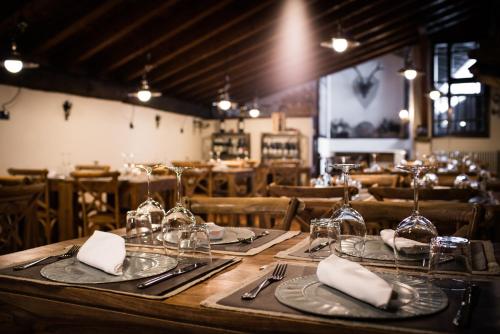 a wooden table with plates and glasses and napkins at Hotel La Grange - Animal Chic Hotel in Courmayeur