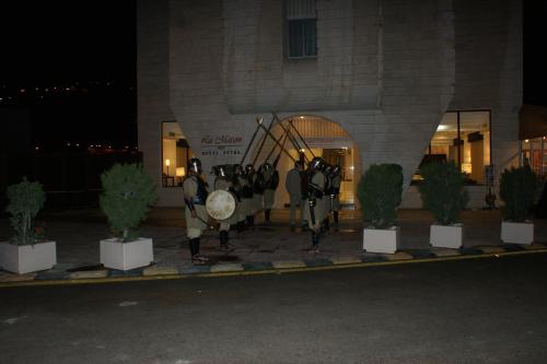a group of people standing in front of a building at La Maison Hotel in Wadi Musa
