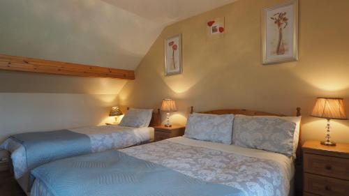 2 letti posti uno accanto all'altro in una camera da letto di Stonehaven B&B a Ennis