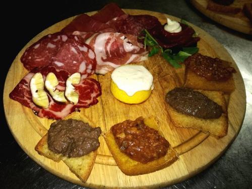 a wooden plate with different types of food on it at Relais Villa Poschi in Pugnano