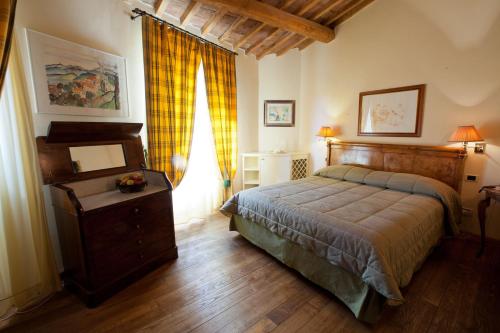 a bedroom with a bed and a table and a window at Locanda Caino in Montemerano
