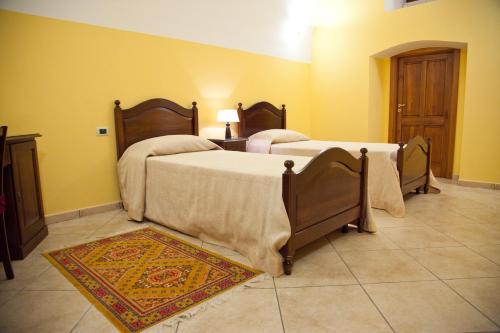 two beds in a room with yellow walls at Villa Musica in Sannicola