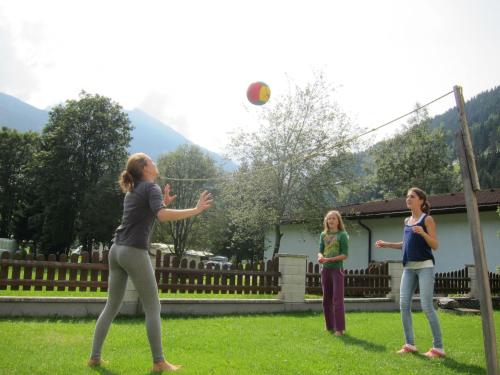 three girls playing with a ball in a yard at Appartement Millennium in Bad Gastein