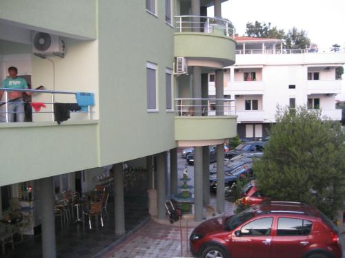 a red car parked in a parking lot next to a building at Guest House Vila Mimoza in Ulcinj