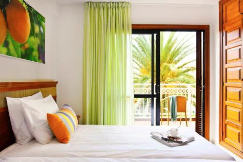 a bedroom with a bed with a view of a patio at Coral Compostela Beach in Playa de las Americas