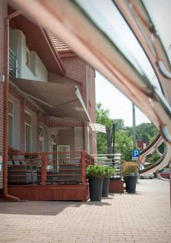 a porch of a building with benches and plants at Hotel Capitol in Biała Podlaska