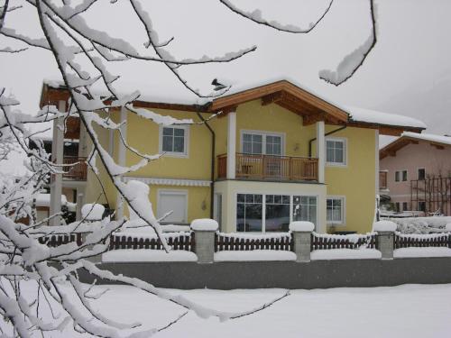 ein Haus mit einem Zaun im Schnee in der Unterkunft Appartement Millennium in Bad Gastein