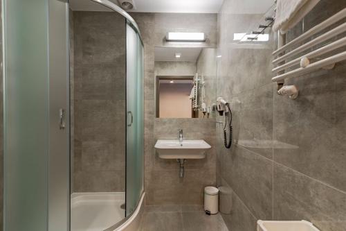 La salle de bains est pourvue d'un lavabo, de toilettes et d'une douche. dans l'établissement WIND Hotel, à Grzybowo
