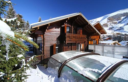 uma cabana na neve com um carro à frente em Odalys Chalet Le Ponton em Les Deux Alpes