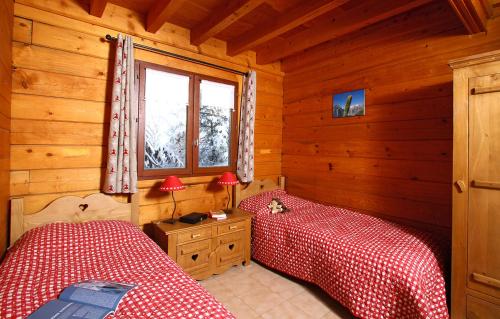 um quarto com 2 camas num chalé de madeira em Odalys Chalet Le Ponton em Les Deux Alpes