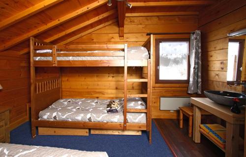 um quarto com beliches num chalé de madeira em Odalys Chalet Le Ponton em Les Deux Alpes
