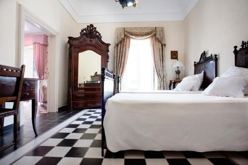 モーディカにあるDimora Birullàのチェック入りのフロア、大型ベッド付きのベッドルーム1室が備わります。
