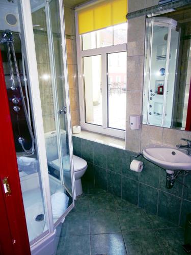 a bathroom with a sink and a toilet and a window at Hotel Bartis in Bartoszyce