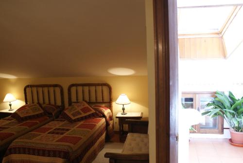 a bedroom with two beds and a window at Casa Rural El acebo in Prádena