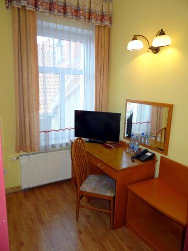 a room with a desk with a computer and a window at Hotel Bartis in Bartoszyce