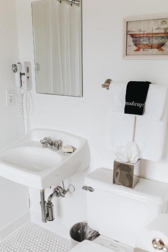 a white bathroom with a sink and a mirror at Chebeague Island Inn in Royal Junction