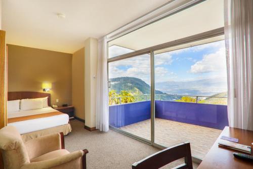 pokój hotelowy z łóżkiem i dużym oknem w obiekcie Hotel Quito w mieście Quito