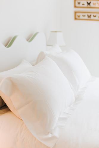 a close up of a bed with white sheets at Chebeague Island Inn in Royal Junction