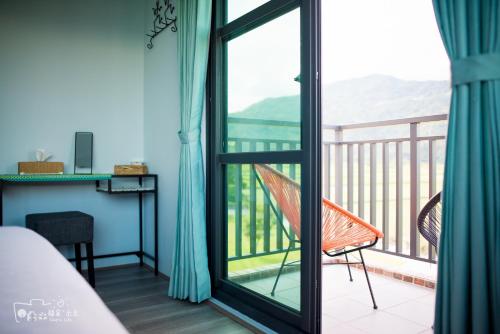 a room with a balcony with a desk and a chair at Simple Life in Yuli