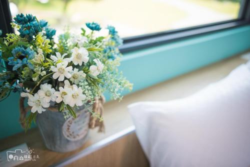 a vase of flowers sitting on a window sill at Simple Life in Yuli