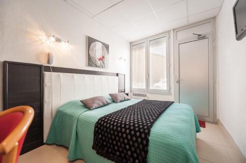 Un pat sau paturi într-o cameră la Hôtel de la Plage