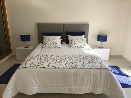 ヴィーラ・ノーヴァ・デ・カセラにあるVilla Lotaのベッドルーム(青いランプ付きの白い大型ベッド1台付)