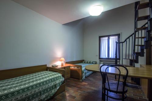 GioveにあるAntico Casale Le Fossateのベッド2台、デスク、テーブルが備わる客室です。