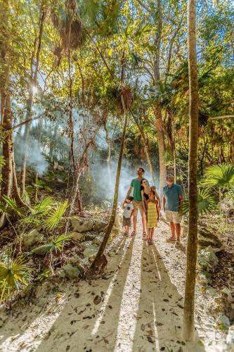 a group of people walking down a path in the jungle at Occidental at Xcaret Destination - All Inclusive in Playa del Carmen