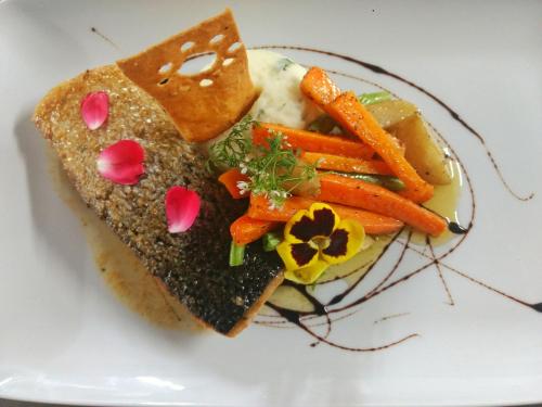 a white plate with a sandwich with carrots on it at Hotel Las Puertas de Tepoztlan in Tepoztlán