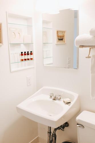 a white bathroom with a sink and a mirror at Chebeague Island Inn in Royal Junction