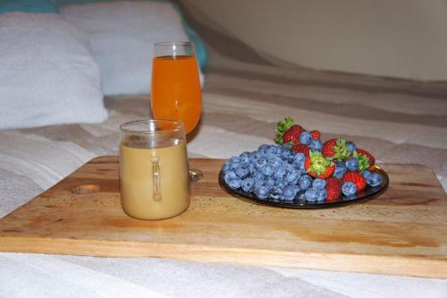 a glass of orange juice next to a plate of fruit at Dom Wilków in Leoncin