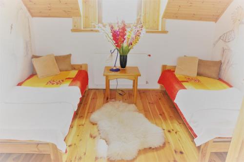 a living room with two couches and a table with flowers at Dom Wilków in Leoncin