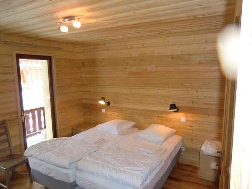 レ・デュー・アルプにあるOdalys Chalet Erikaの木製の部屋にベッド1台が備わるベッドルーム1室があります。