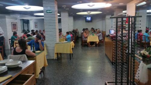 a group of people sitting at tables in a restaurant at Palace Hotel in Miramar