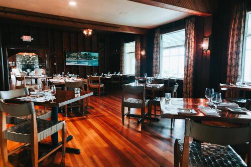 a restaurant with wooden floors and tables and chairs at Chebeague Island Inn in Royal Junction