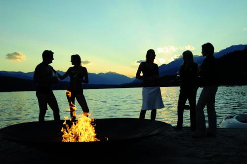 a group of people standing around a fire pit at Familienhotel Steindl in Millstatt