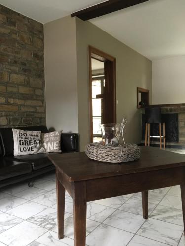 a living room with a table and a couch at Le gîte de la vieille église in Tenneville