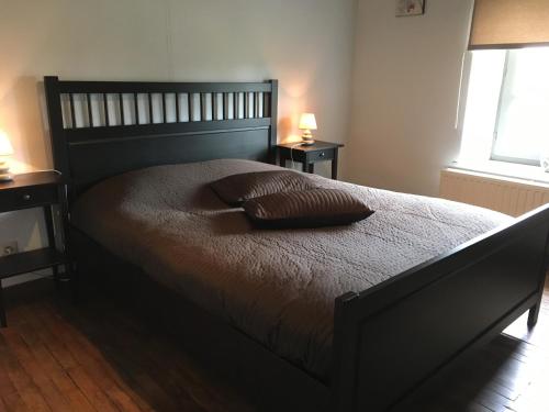 a bedroom with a large bed with two pillows on it at Le gîte de la vieille église in Tenneville