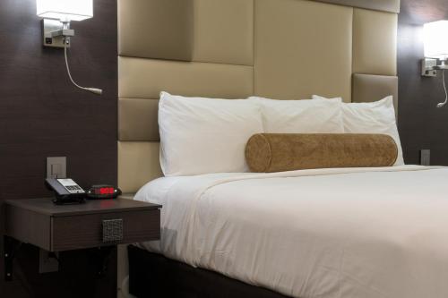 a hotel room with a bed with a pillow on it at Hotel Xilo Glendale in Glendale