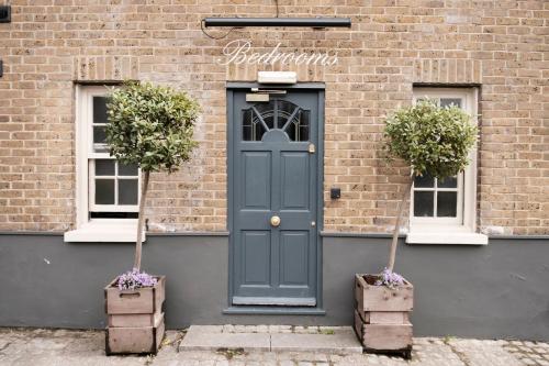 a blue door on a brick building with two windows at The Pilot Inn in London
