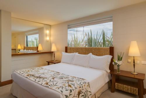 een slaapkamer met een groot bed en een groot raam bij Blue Tree Towers Caxias do Sul in Caxias do Sul