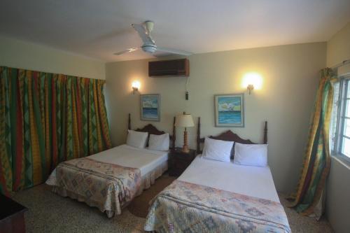 a hotel room with two beds and a window at Sahara Hostel in Montego Bay