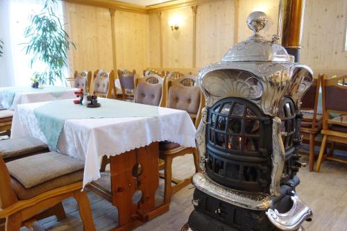 a dining room with a table and a fire place at Penzion u Veselých in Pec pod Sněžkou