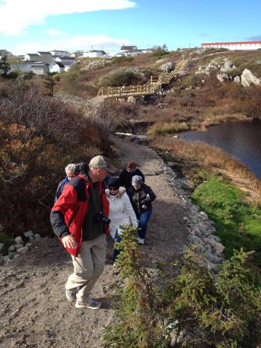 a group of people walking down a dirt trail at St Christopher's Hotel in Channel-Port aux Basques