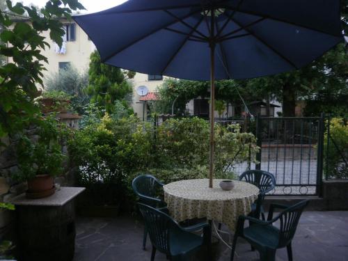a table with a blue umbrella on a patio at BeB Angelini dal 1911 in Lucca