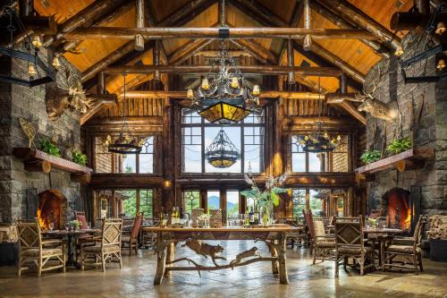 a dining room with a large wooden table and chairs at The Whiteface Lodge in Lake Placid